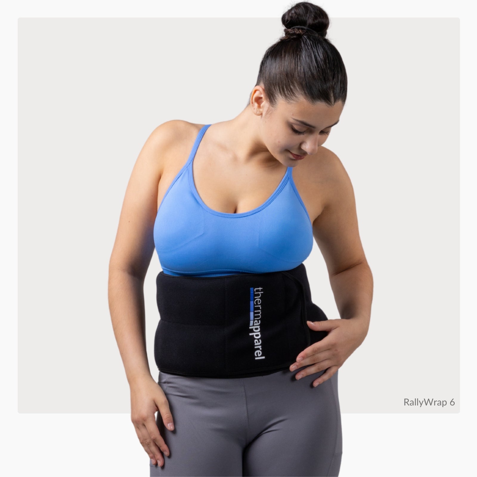 Woman wearing a ThermApparel RallyWrap with 'ThermApparel' branding  logo on a white background