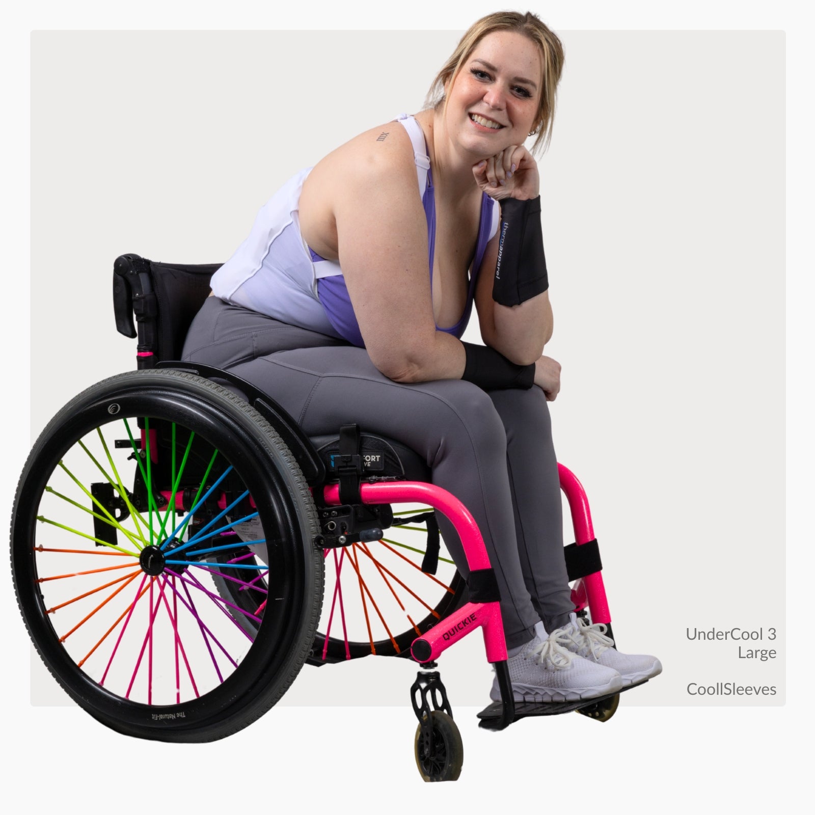 Woman in a wheelchair with colorful wheel design wearing a ThermApparel UnderCool 3 and CoolSleeves on a white background